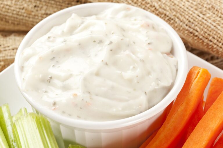 A Large Bowl of Ranch Dressing with Carrots and Celery