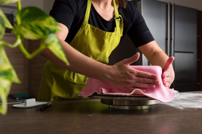 Woman in Bakery Smoothing Fondant on Heart Shaped Cake