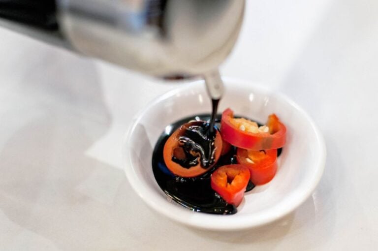 Sweet, Dark Chinese Soy Sauce Poured Into Bowl With Red Chilies