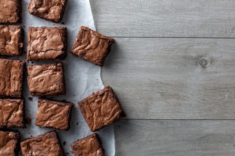 Cut Chocolate Brownies on Parchment Paper on a Gray Table