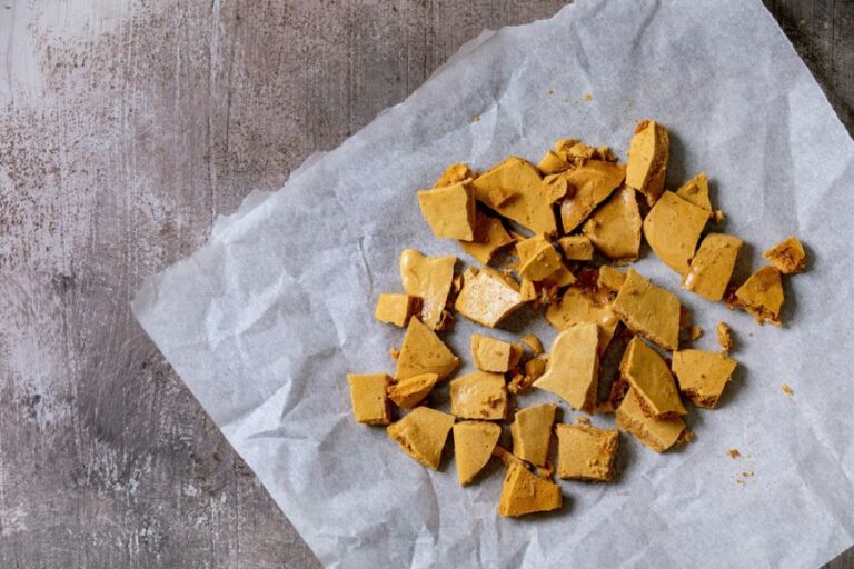 Broken Pieces of Cinder Toffee on a Piece of Parchment Paper