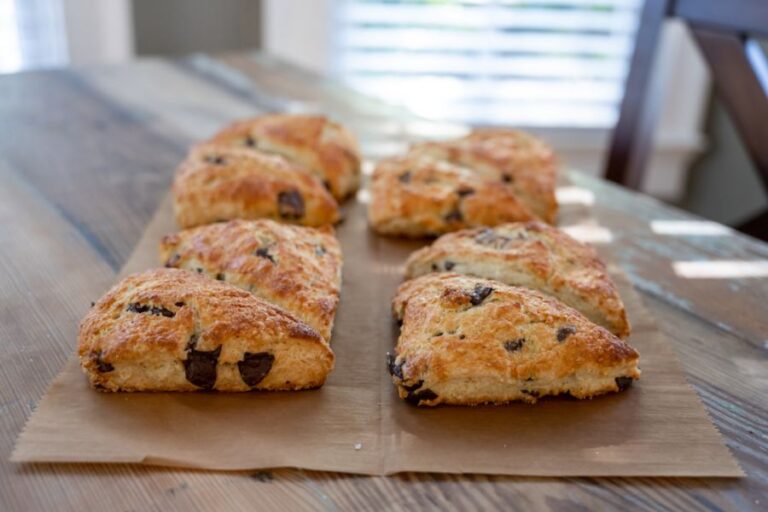 Chocolate Chip Scones Laid on Parchment Paper on a Wooden Table