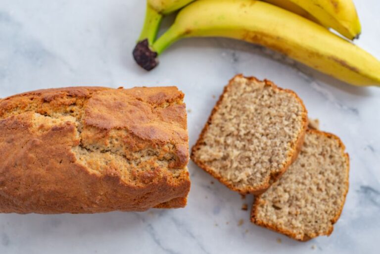 Sliced Banana Bread With Ripe Bananas in the Background