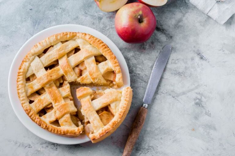 Apple Pie on a White Plate With a Large Slice Cut