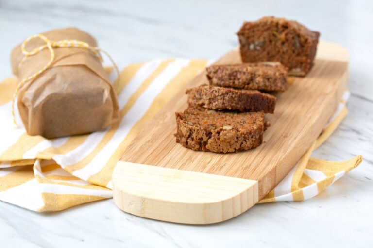 Sliced Zucchini Bread on a Cutting Board Next to a Wrapped Loaf