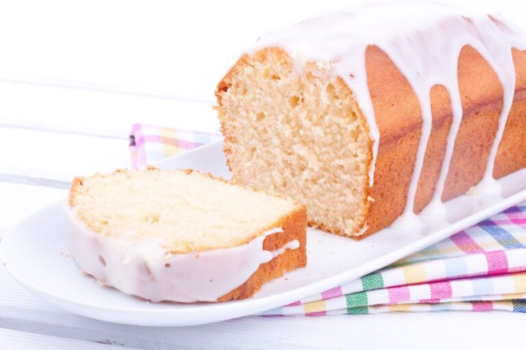 Glazed Lemon Pound Cake Sliced on a White Plate