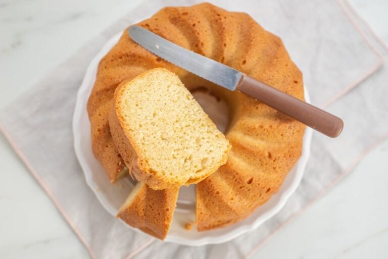 Pound Cake Cut on a White Plate With a Knife on Top