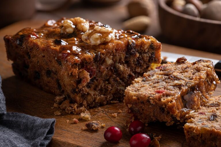 Sliced Fruit Cake on a Dark Wooden Cutting Board