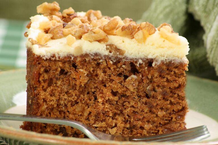 A Slice of Carrot Cake Topped With Walnuts