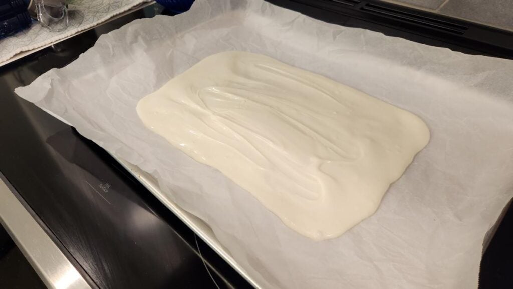 Melted White Chocolate Spread Out on Parchment Paper