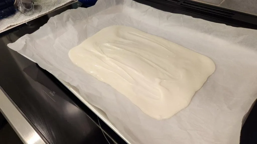 Melted White Chocolate Spread Out on Parchment Paper